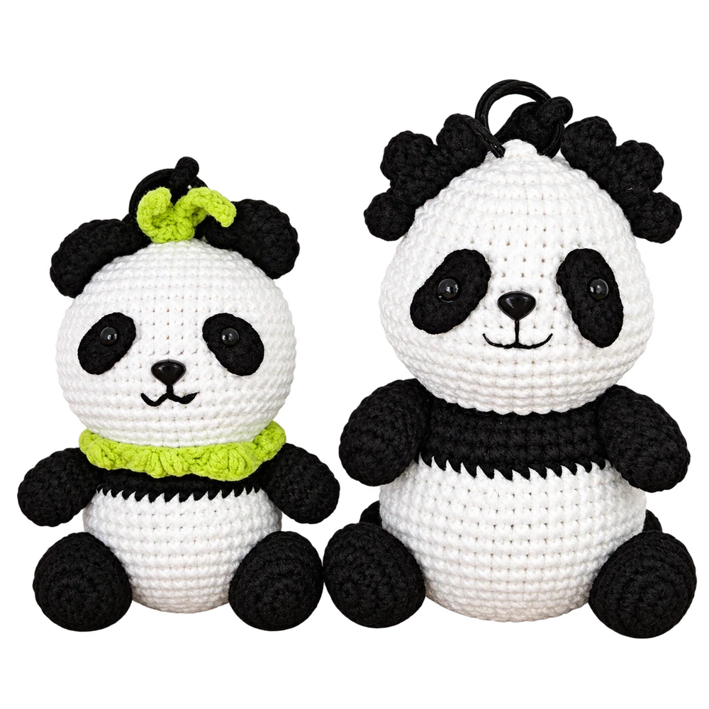Two handmade black-and-white crochet pandas with green scarf and bow details